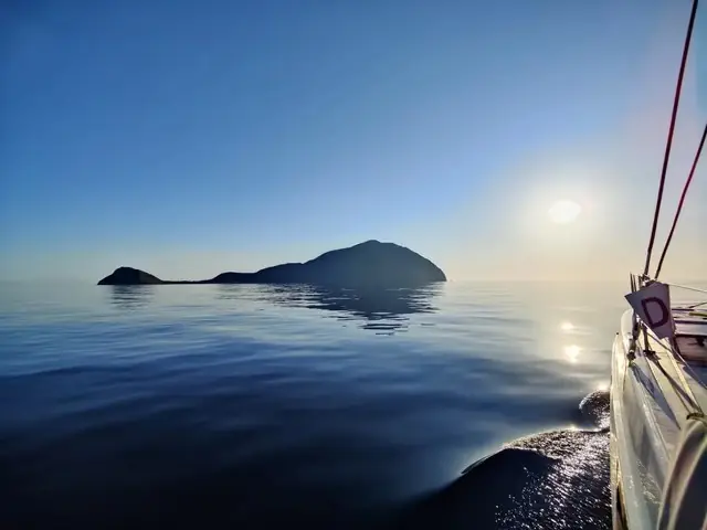 Un isolotto che emerge dal mare calmo del mattino