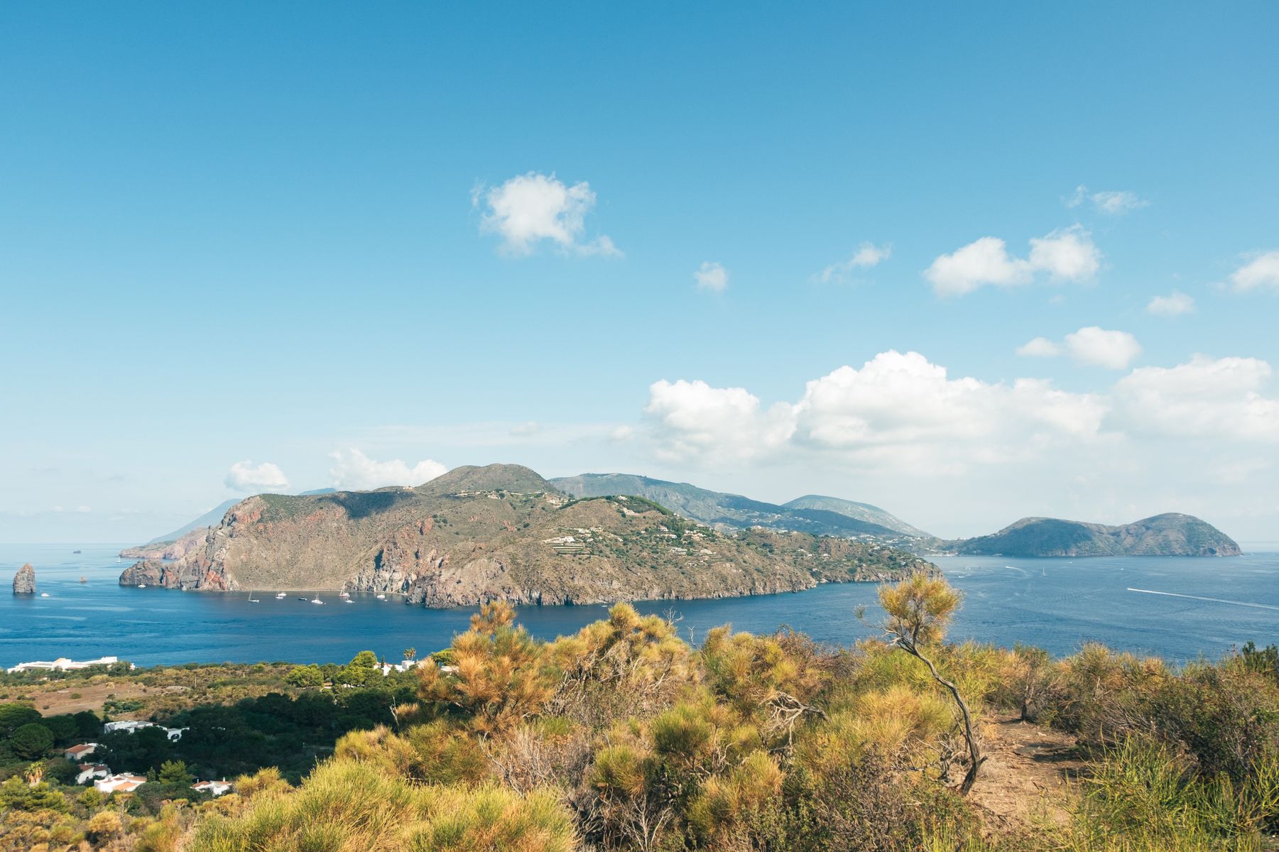 Un'isola vulcanica del Mediterraneo vista dall'alto, con il mare calmo e le barche all'ancora
